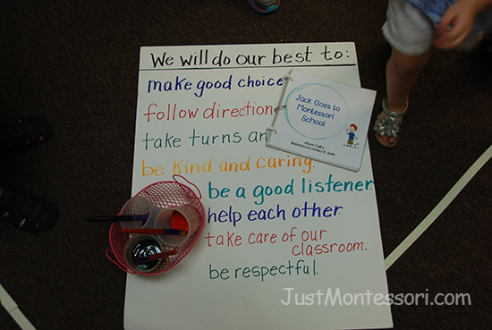 Children make painted hand prints on the poster