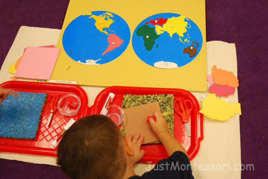 An older child is working on poking out the continents to make a hemisphere map. 