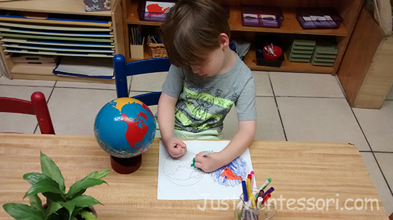 A younger child coloring a hemisphere map.