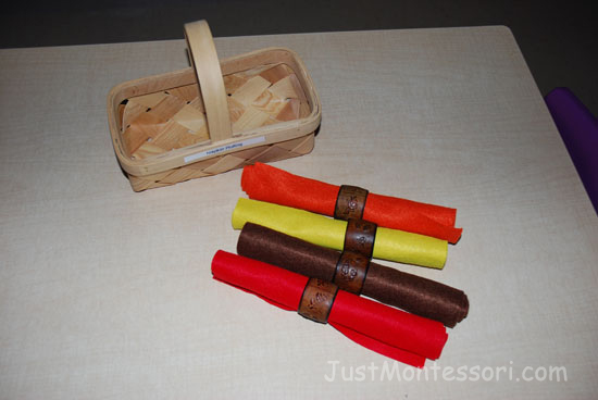 These are felt pieces pieces that are rolled and placed in napkin rings. There are small leaves around the napkin rings. I like using felt before cloth napkins because it is a bit firmer and easier for the younger children.